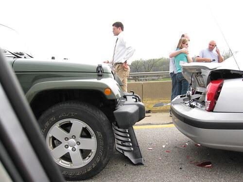 People standing outside after car accident and talking about insurance