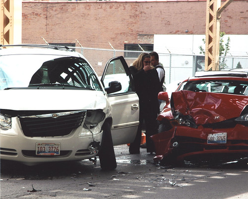 Minivan and Coupe crashed while people look at the damage