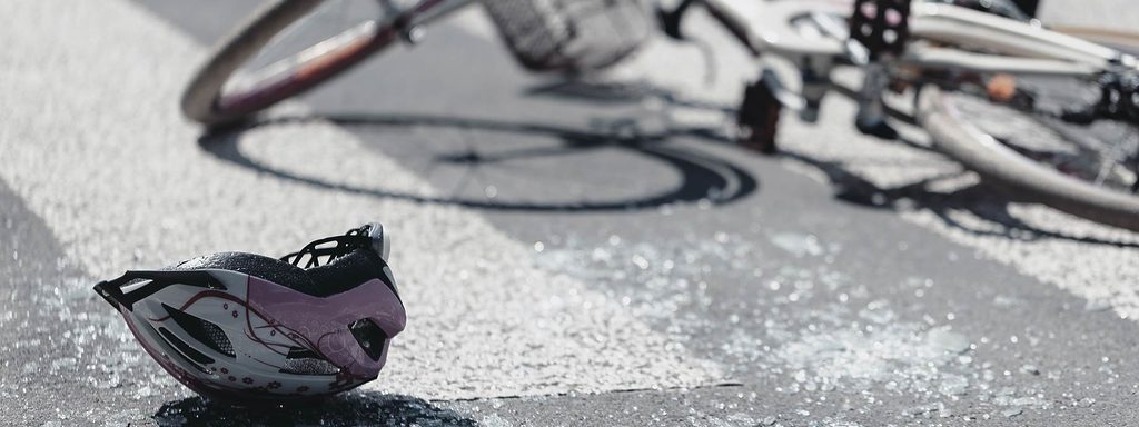 Fallen bicycle and cycling helmet on the pavement after a collision