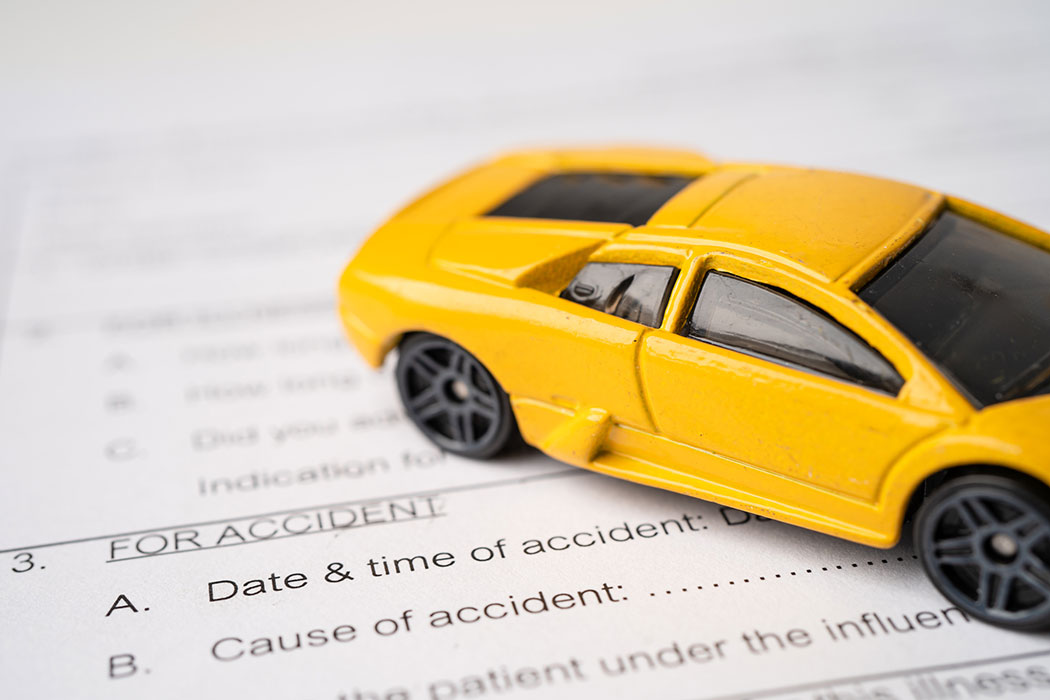 Toy car on top of an insurance claim form, symbolizing filing a car accident claim before the statute of limitations expires.