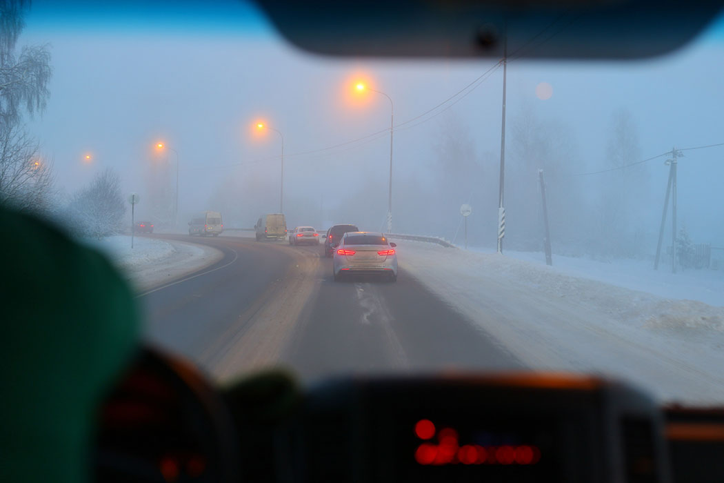 Car driving through fog and snow on a winter highway, illustrating dangerous conditions that cause crashes on Detroit’s I-94 and Lodge Freeway.