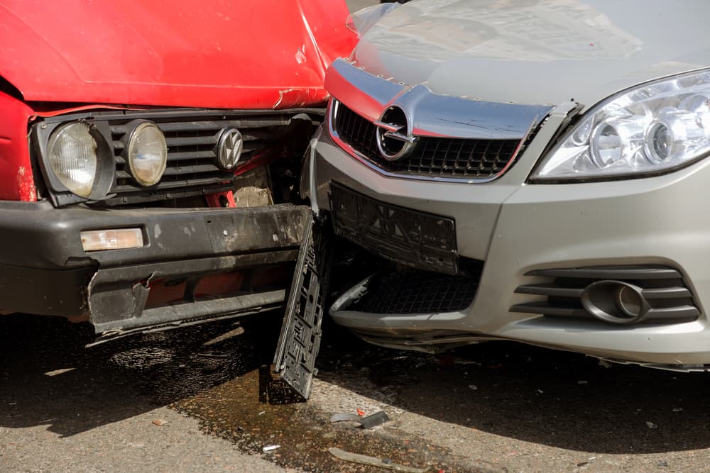 Front-end collision between two cars on a city street, illustrating what to do after a car accident in Grand Rapids, Michigan.