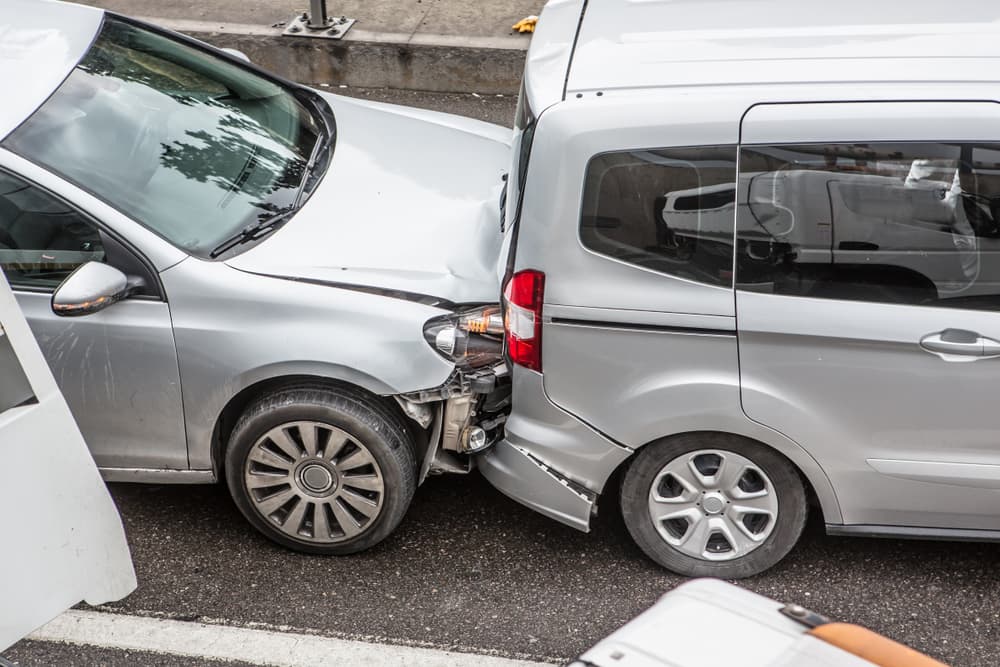 Two vehicles in a rear-end collision on a city street, illustrating common locations where car accidents occur in Detroit.