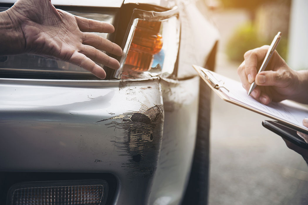Insurance agent documenting a car accident claim, tied to fault decisions and rate hikes in Dearborn
