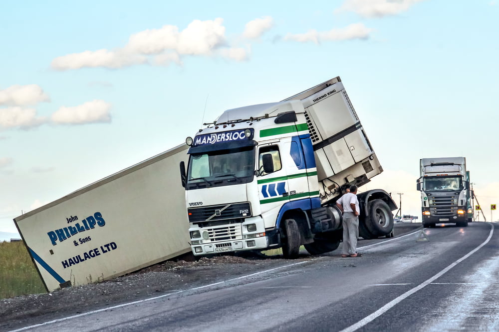 Jackknifed semi-truck blocking part of a highway after a commercial truck accident. 